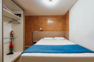 um quarto com uma cama com um cobertor azul em Tropical Itapema em Itapema