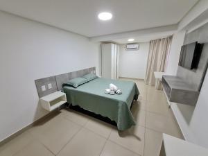 1 dormitorio con 1 cama y TV en Gold Flat - Miramar Hospedagens en João Pessoa
