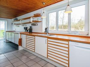 OrnumにあるSix-Bedroom Holiday home in Aabenraaのキッチン(白いキャビネット、木製カウンタートップ付)