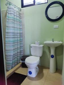 a bathroom with a toilet and a sink at Casa Black Chaini in Puerto Viejo