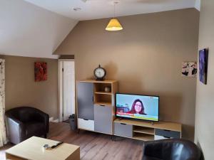 uma sala de estar com uma televisão de ecrã plano e uma mesa em Apt. 2 - Town Centre Apartment em Bagenalstown