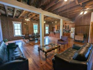 a living room with a leather couch and a table at Arcadia Academy in Arcadia