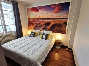 Un dormitorio con una cama con un cuadro en la pared. en PORT-ROUSSE - La Rouliere, en Les Sables-dʼOlonne