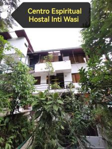 a building with a bunch of plants in front of it at Centro Espiritual Hostal Inti Wasi in Machu Picchu