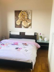 a bedroom with a bed with a flower painting on the wall at Privatzimmer Boardinghouse/Messe Düsseldorf in Viersen