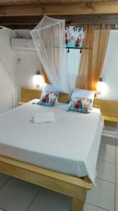 a bedroom with a white bed with a canopy at Les Hauts de Bornave in Deshaies