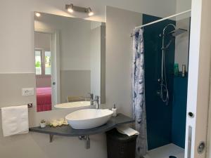 ein Bad mit einem Waschbecken und einem Spiegel in der Unterkunft White House monolocale in Avola