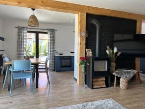 a kitchen and dining room with a table and a fireplace at Villa Kama in Giżycko