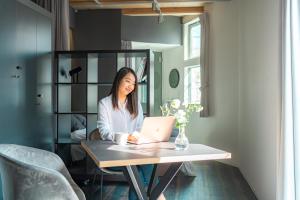 a woman sitting at a table with a laptop at Corent代田橋 in Tokyo