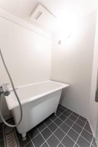a white bath tub in a bathroom with a tile floor at Corent代田橋 in Tokyo