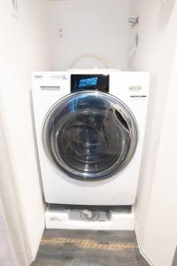 a washer and dryer in a white room at Corent代田橋 in Tokyo