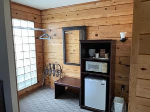 a kitchen with a wooden wall with a microwave and a table at Walla Walla Garden Motel in Walla Walla