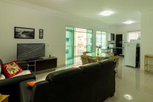 een woonkamer met een bank, een tv en een tafel bij Supremo in Meia Praia
