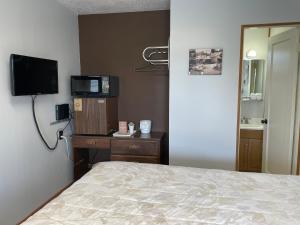a bedroom with a bed and a tv and a mirror at Walla Walla Garden Motel in Walla Walla