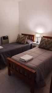 a hotel room with two beds and a table at LA ESTACION in Gualeguaychú