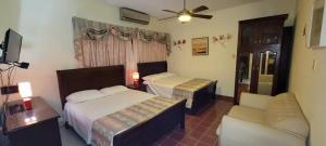 um quarto de hotel com duas camas e um sofá em Torres Apart Studio em Santo Domingo