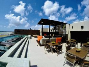 a patio with tables and chairs next to a swimming pool at Holandas Prime Tambaú in João Pessoa