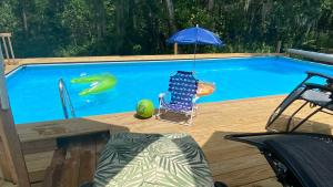 a swimming pool with a chair and an umbrella at º Tropical Escape Sarasota º Experience Florida Up-close! in Sarasota