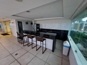 a kitchen with chairs and a counter in a kitchen at Pacific Flat da Miramar in Tambaú