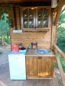 cocina al aire libre con fregadero y nevera en Cozy Treehouse with private sand beach, en Blagaj