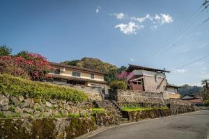 una casa en una pared de piedra junto a una calle en ojirotomarlo, 
