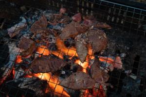 un montón de carne cocinando en una parrilla en ojirotomarlo, 