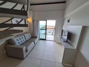 een woonkamer met een bank en een tv bij Laguna Beach Porto de Galinhas in Camela
