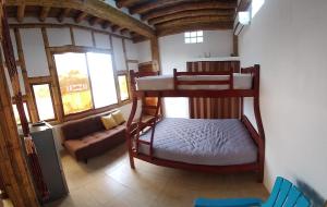 een slaapkamer met 2 stapelbedden en een bank bij MANGLARALTO BEACH SUITE'S in Montañita
