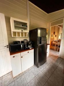 uma cozinha com um frigorífico de aço inoxidável e armários brancos em Casa Renascer em Fernando de Noronha