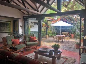 een woonkamer met een patio met een tafel en een parasol bij Casa Tirteo ( A 500 m de la plaza principal) in Villa de Leyva