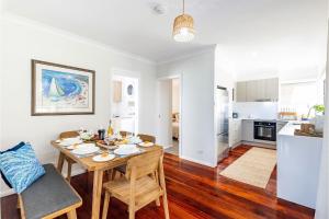 a kitchen and living room with a table and chairs at Banksia at Fingal 1 92 Rocky Point Rd Aircon spa and Wi Fi in Fingal Bay