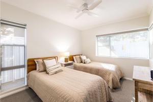 a bedroom with two beds and a window at Banksia at Fingal 1 92 Rocky Point Rd Aircon spa and Wi Fi in Fingal Bay