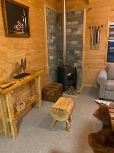 a living room with a fireplace and a stove at Cabaña Loica - 2 Hermanos in Coihaique