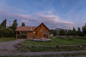 Cabaña de madera con porche en un campo en Cabañas 2 Hermanos, en Coyhaique