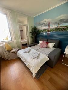 a bedroom with two beds and a painting of a bridge at Graca Charming in Lisbon