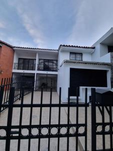 a black fence in front of a white building at Hospedaje Casa Leví in Cali