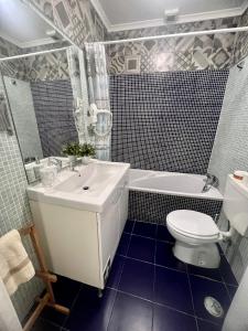 a bathroom with a sink and a toilet and a tub at Graca Charming in Lisbon