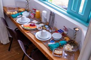 - une table avec de la nourriture pour le petit-déjeuner dans l'établissement Pousada Vila Suiça - Monte Verde, à Monte Verde