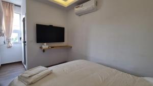 - une chambre avec un lit et une télévision à écran plat dans l'établissement Luxurious and cosy studio, à Abidjan