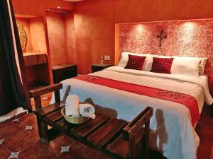 a bedroom with a large bed and a table at Hotel & Cava La Parroquia in San Cristóbal de Las Casas