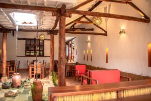restauracja z czerwonymi krzesłami i stołami w pokoju w obiekcie Hotel Tierra Roja By MH w mieście Barichara