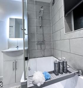 a bathroom with a shower and a sink and a tub at Cosy Contemporary Apartment - Brimsdown, Enfield in Enfield Lock