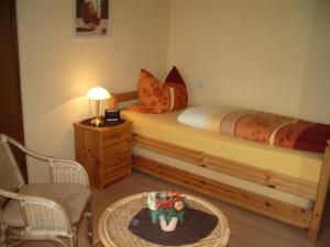 ツェルティンゲン・ラハティグにあるGästehaus Resiのベッドルーム1室(ベッド1台、テーブル、椅子付)