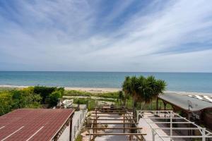 a view of the beach from a balcony at SEAFRONT SUITE 5 Stars - Comfortable Apartment in Marina di Strongoli +10 photos