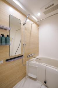 a bathroom with a shower with a mirror at unito KEIKYU-KAMATA in Tokyo