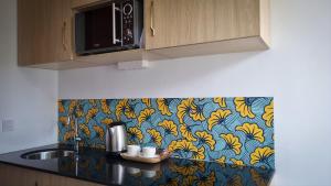 a kitchen with a counter top with a colorful wallpaper at Luxurious and cosy studio in Abidjan