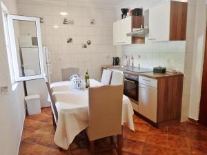 a kitchen with a table with a white table cloth at Apartments by the sea Seline, Paklenica - 21208 in Seline