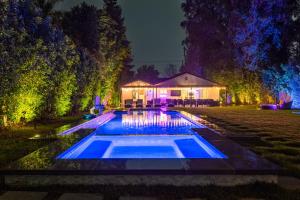 une maison avec une piscine la nuit dans l'établissement Woodland Hills Paradise Resort Style Home, à Los Angeles