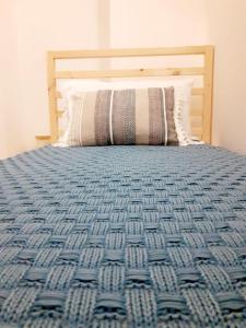 - un lit avec une couette bleue et un oreiller dans l'établissement Casa Borromeo, à Villa Castelli
