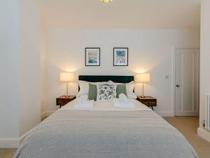 a bedroom with a large bed with two lamps at The Old Guest House in Margate